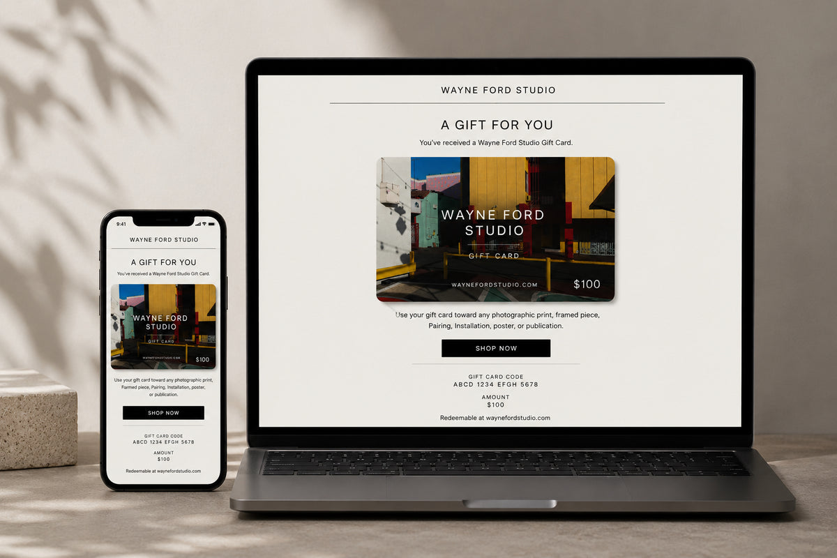 Wayne Ford Studio Gift Card with colorful abstract art, $100 value, shown on a laptop and phone screen.